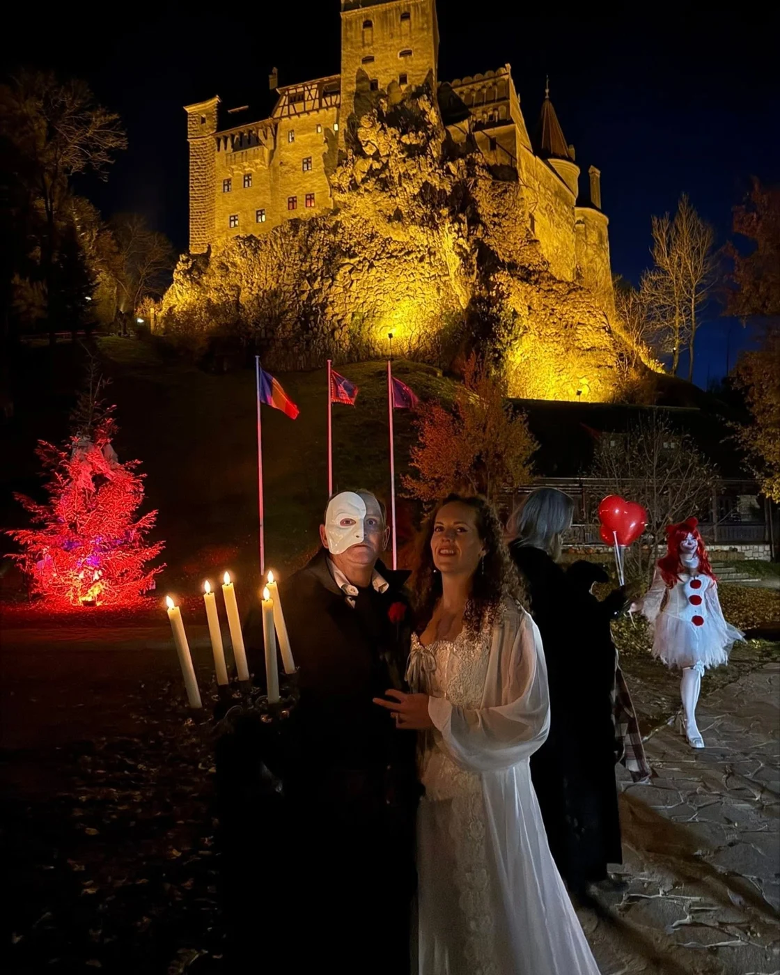 Costumed guests near Bran Castle at night